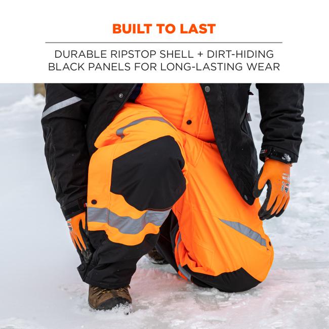 Built to last: durable ripstop shell + dirt-hiding black panels on front for long-lasting wear. Image is person kneeling in the snow wearing bibs.
